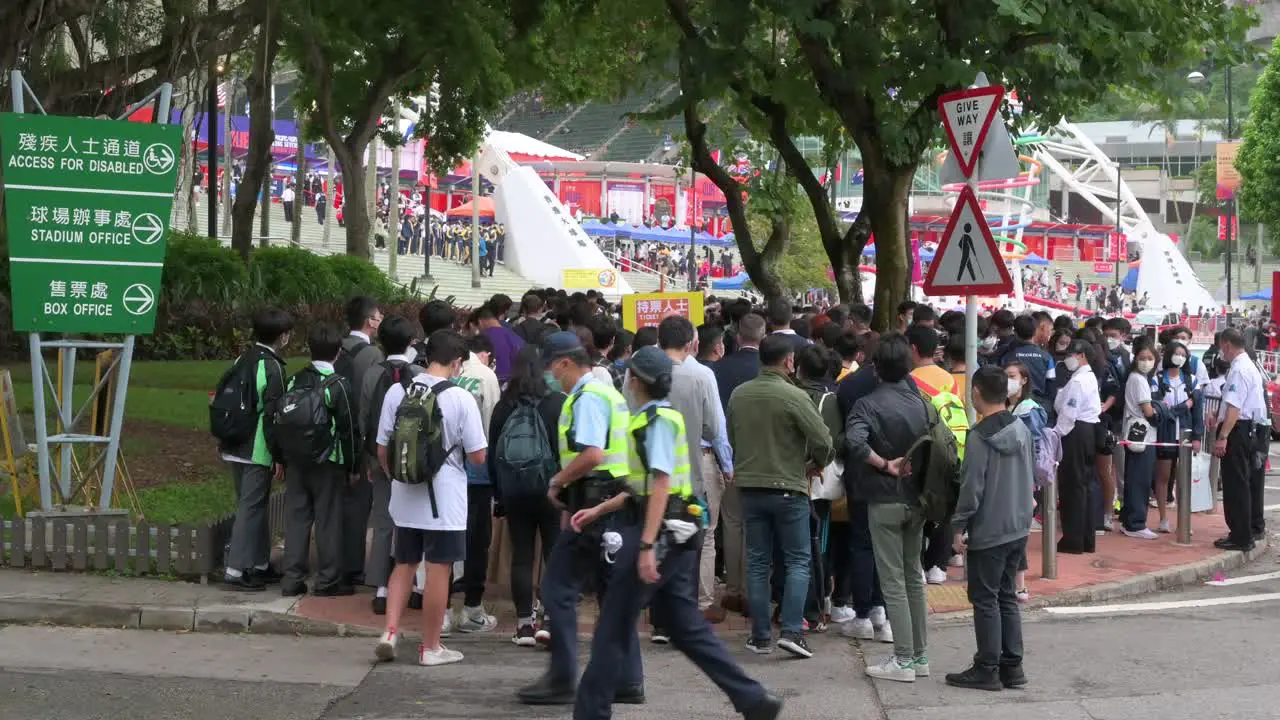 Spectators queue in line to enter the stadium holding the Hong Kong Seven rugby tournament one the city's highest-profile sport event after being cancelled due to covid-19 government restrictions