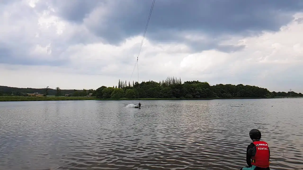 A slow motion shot of a man cable skiing on a lake