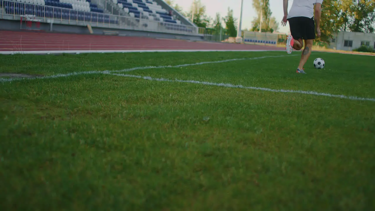 A football player in equipment on the football field receives a pass and technically handles the incoming soccer ball