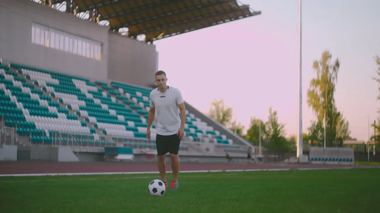 Professional soccer player is juggling a ball socker a player in a white football uniform at the stadium