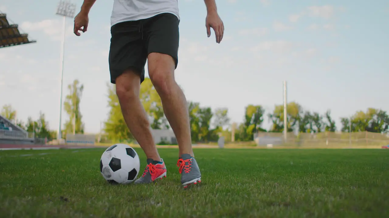 Close-up of a male soccer player running with a soccer ball on the football field in the stadium demonstrating excellent dribbling and ball control