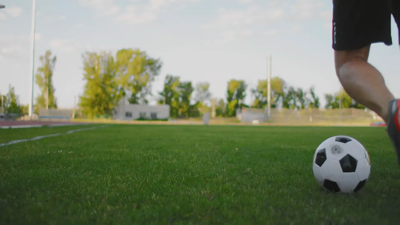 A soccer player at the stadium demonstrates dribbling with a soccer ball while leading a sword while running Excellent skill of a football player and ball control