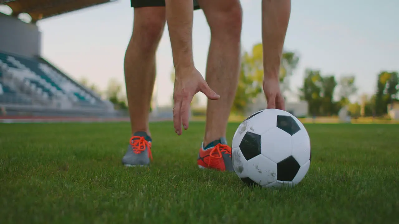 A professional soccer player hits a ball with his head on a football field in slow motion