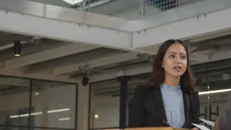 Long Shot of Woman Giving Work to Colleague