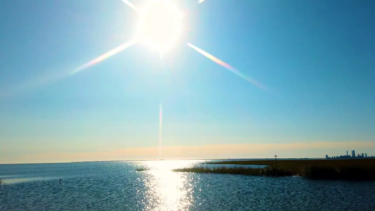 HD MOTIONLAPSE pan left to right from sun and sun reflecting on waterway to Atlantic City skyline in distance on a nice clear day also available in 4K