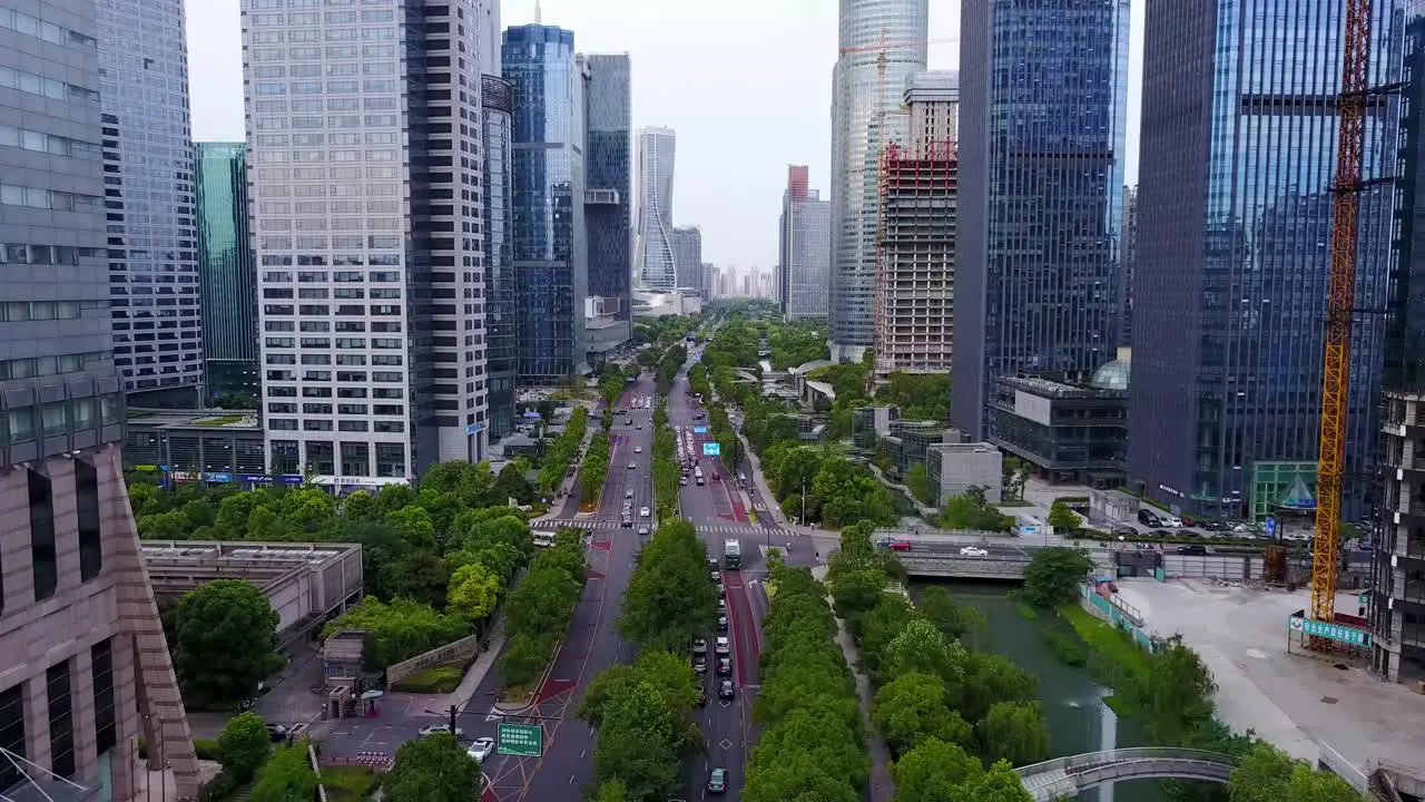 Aerial Shot of Downtown Traffic along the River between Skyscrapers in Hangzhou China