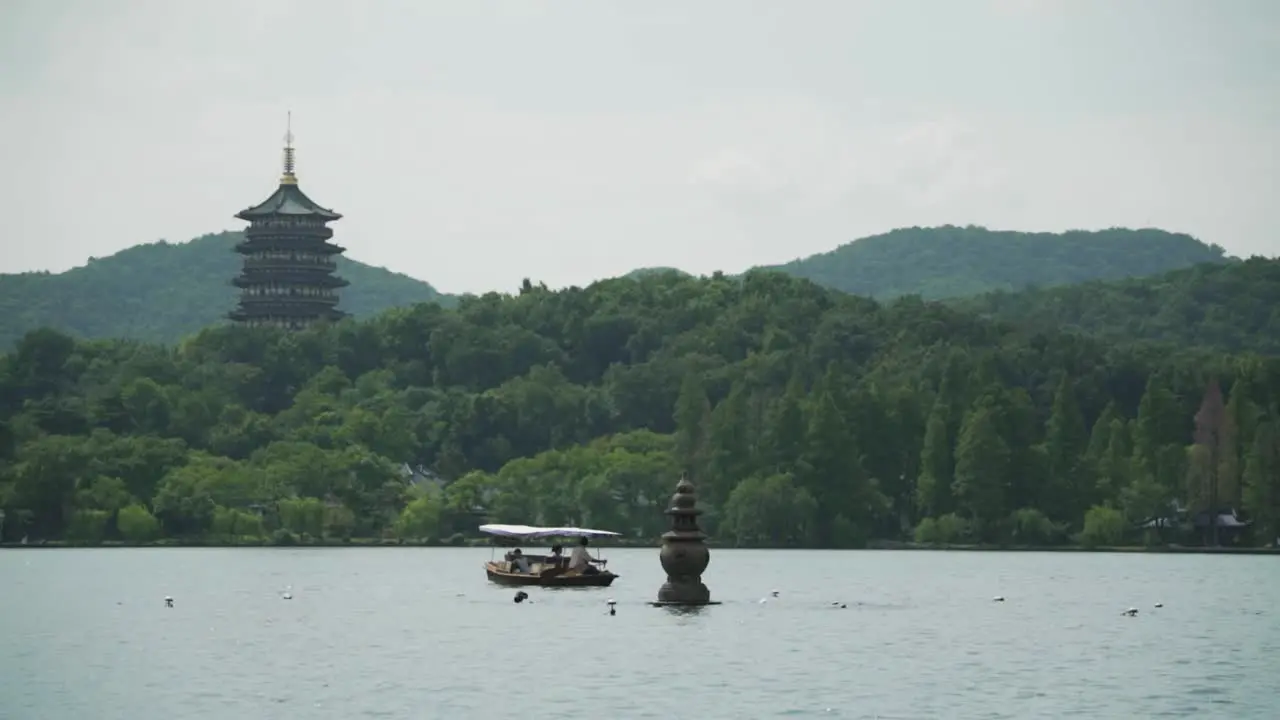 Leifeng pagoda tourist boat and one of the Three Stone Pagodas from the Three Pools Mirroring the Moon West Lake Hangzhou China