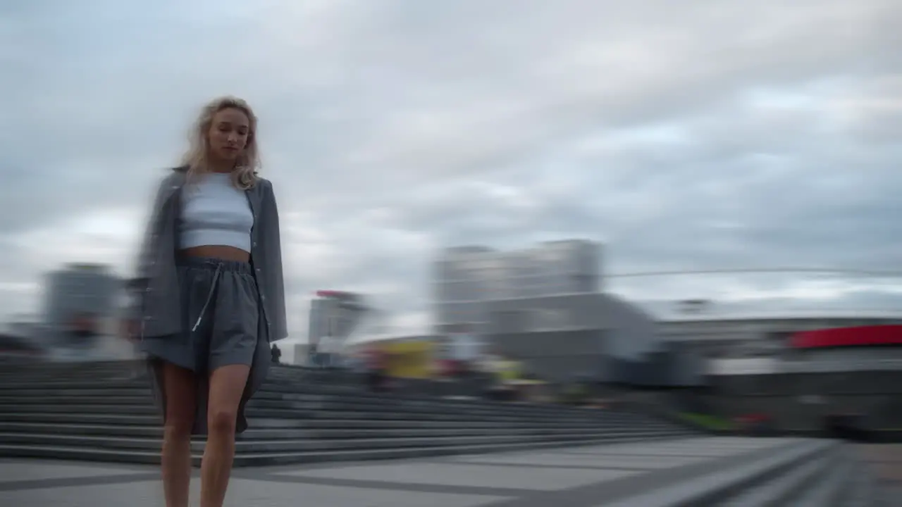 Girl walking down stairs in city centre urban buildings background