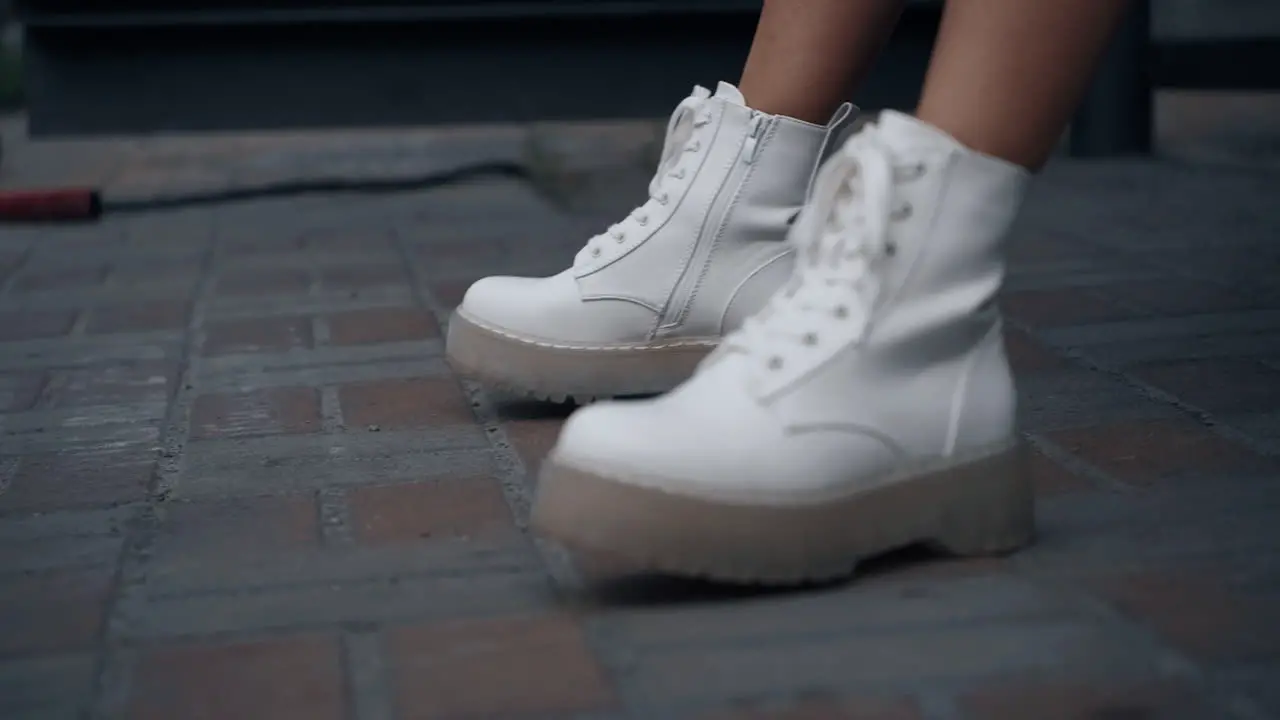 White shoes legs moving on ground in urban city Woman wearing shoes in town