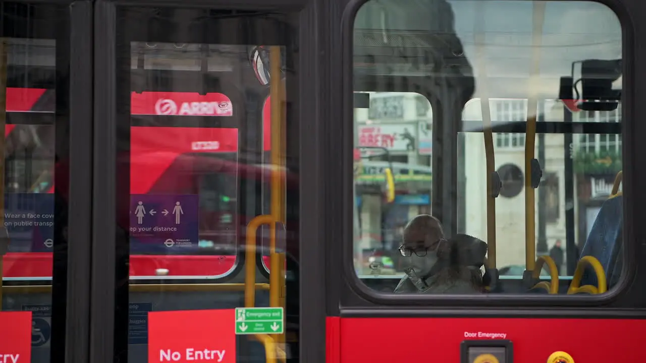 Public transport in London during Coronavirus Covid-19 lockdown with man on red London bus wearing face mask covering when public transport was quiet and deserted with no people in England Europe