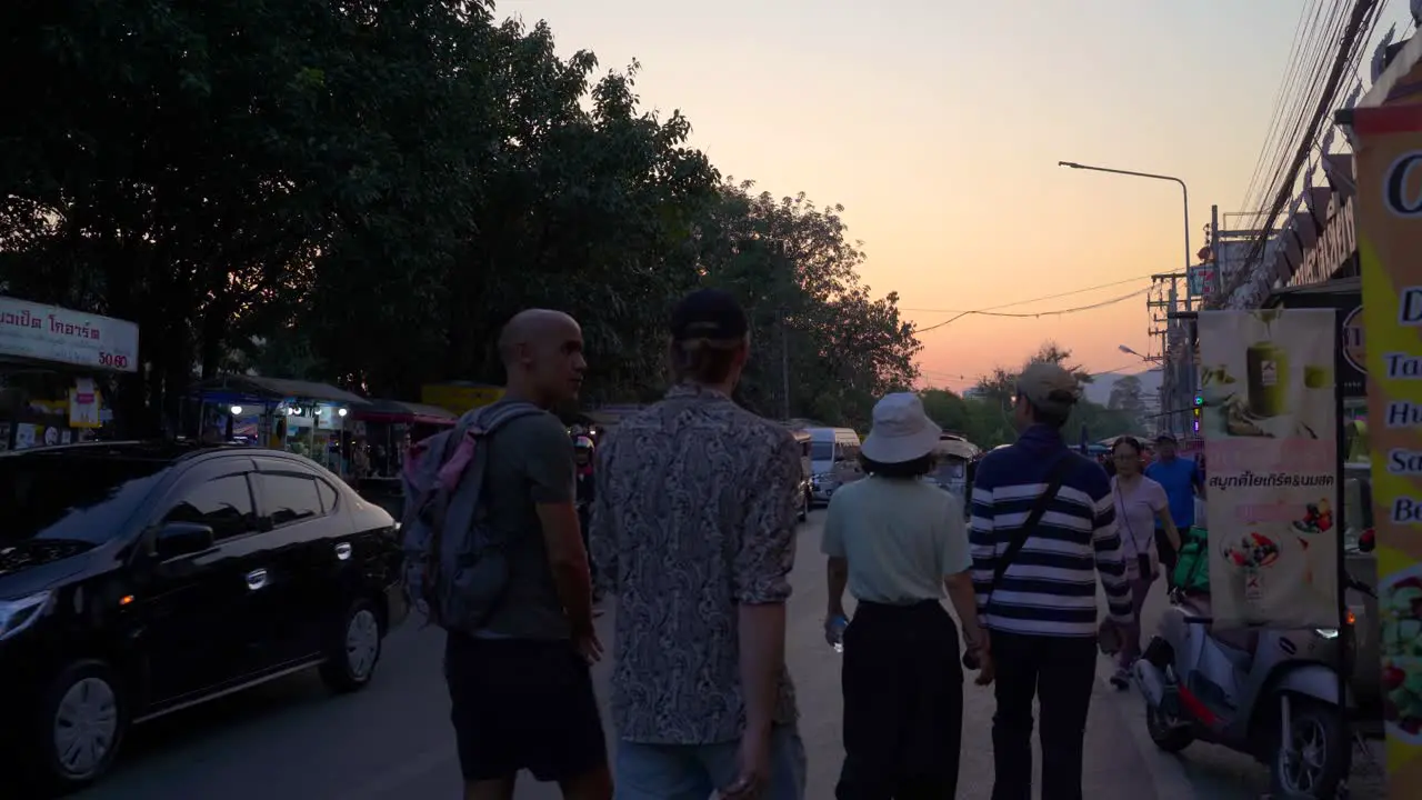 People walking on street of street market at sunset in Thailand