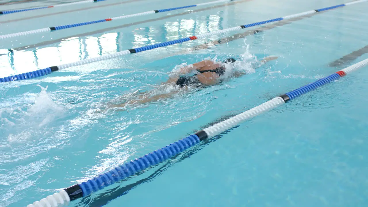 Caucasian female swimmer athlete swimming in a pool