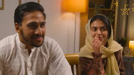 Muslim Family Sitting Around Table At Home Eating Meal To Celebrate Eid 2