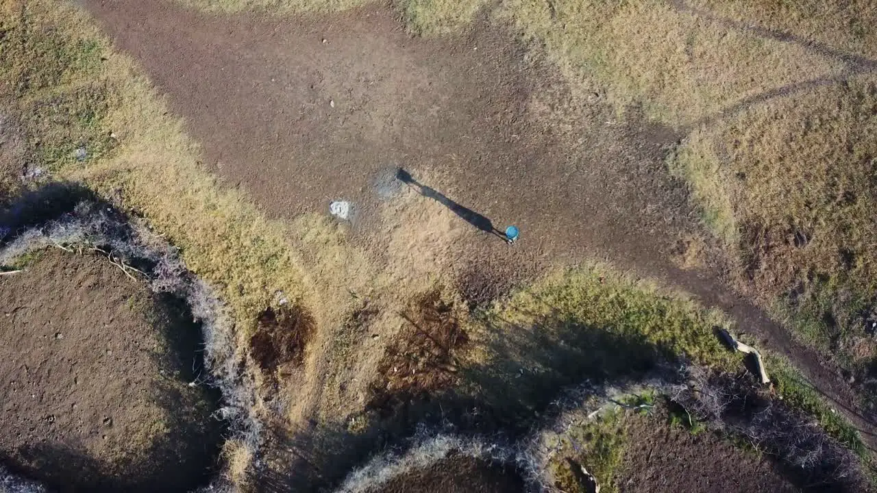 Overhead drone shot of a Karamojong woman carrying things with her head Uganda