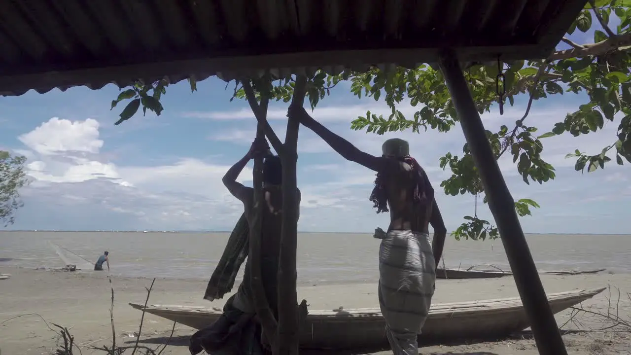 Bangladeshi riverside people are standing in front of the river after the flood has taken away their houses