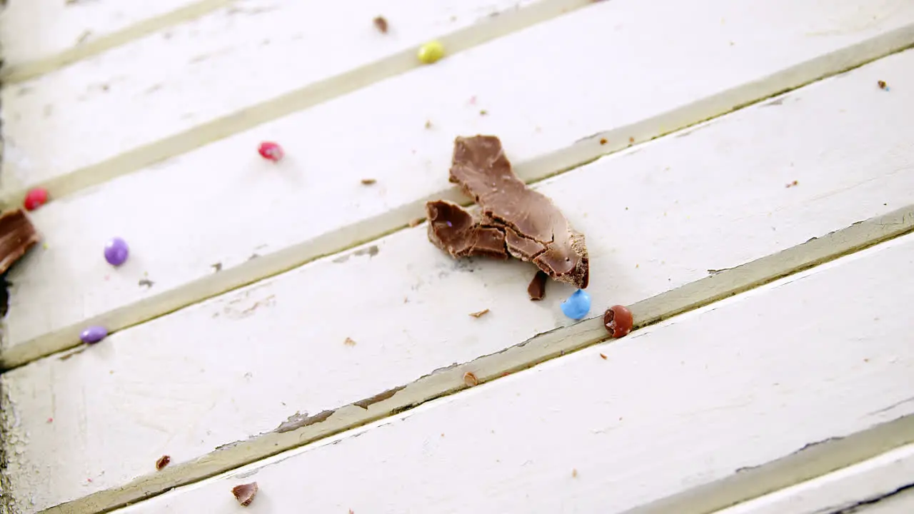 Broken chocolate Easter egg on wooden plank