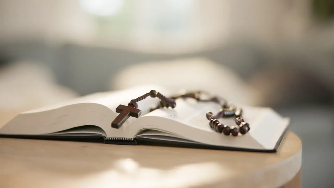 Bible open and rosary on table for religion