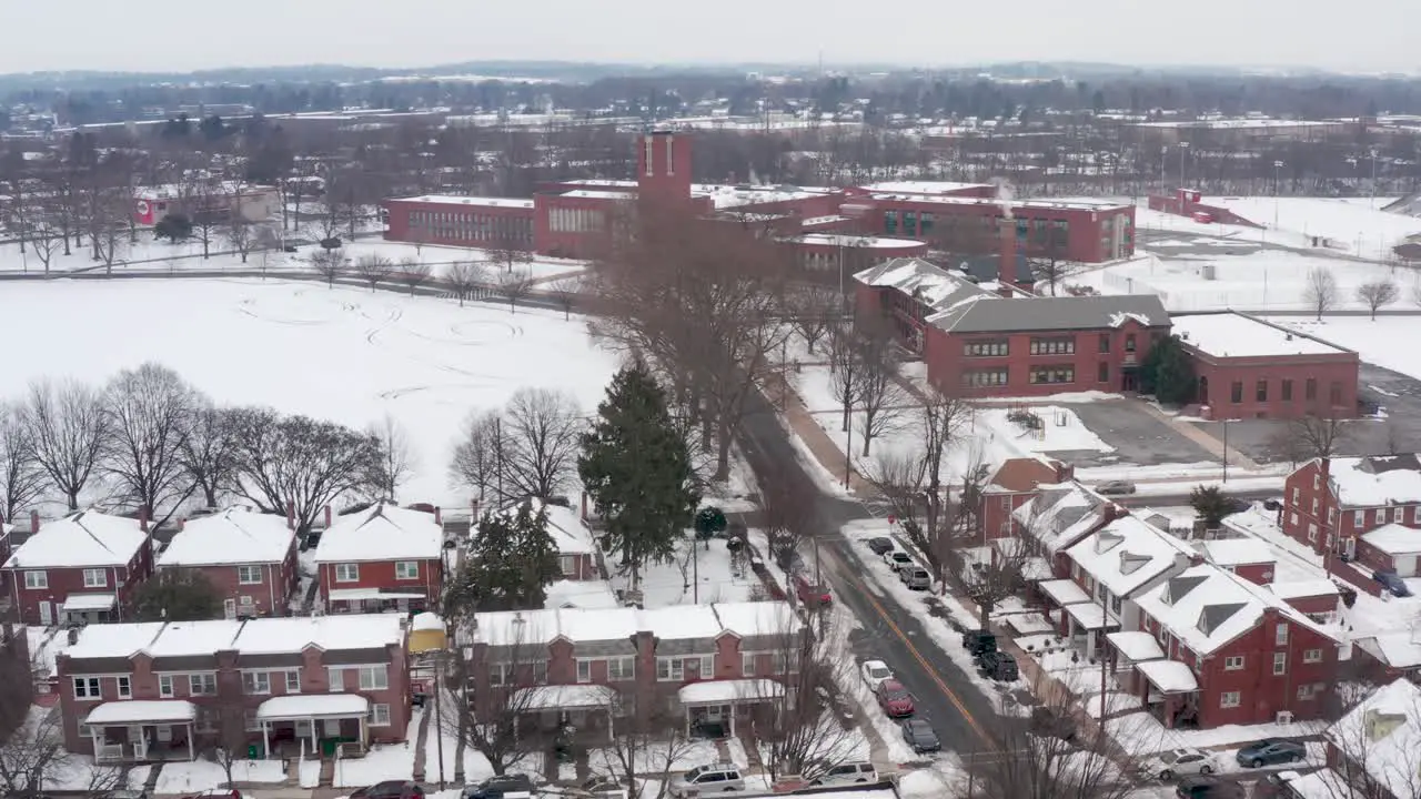 Aerial of urban city housing in USA with school buildings in distance