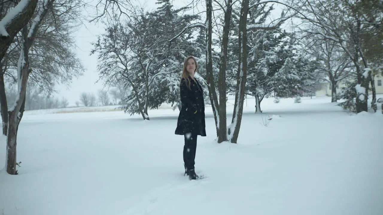 Happy woman outside in slow motion Christmas winter snow as snowflakes fall in cinematic slow motion