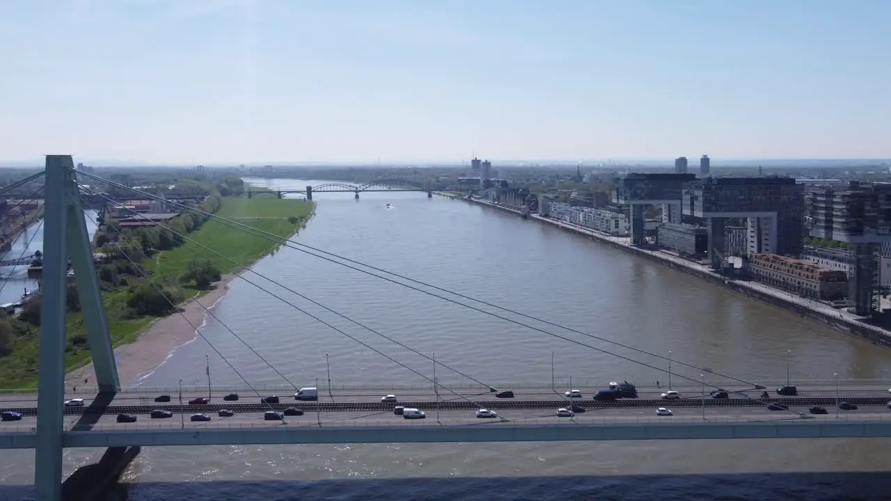 City Traffic on Severin Bridge of Cologne Germany at Rush Hour and Cars crossing Rhine River Crane House Buildings in Background