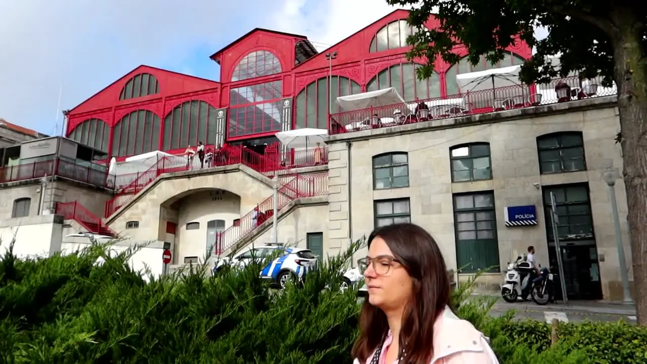 Tourist walks in front of Ferreira Borges Market and Police Station Porto