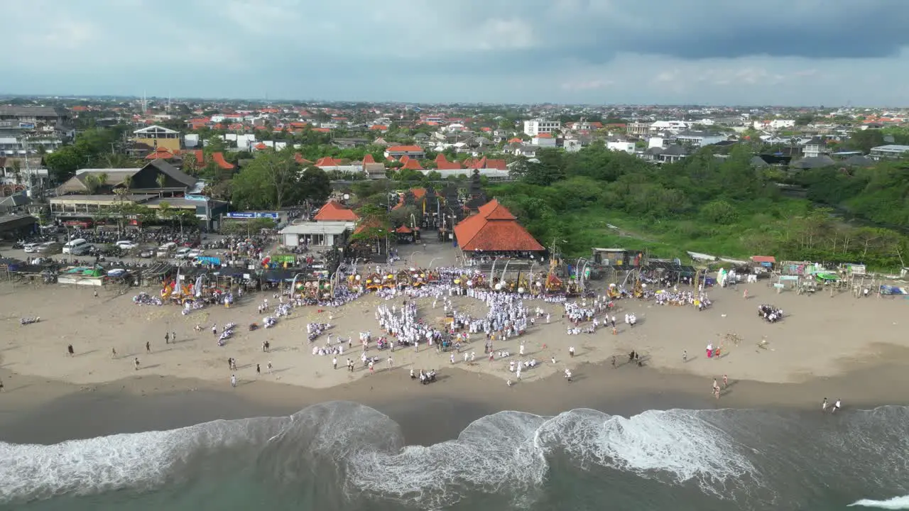 A busy beach full of Balinese people during the Melasti ceremony aerial