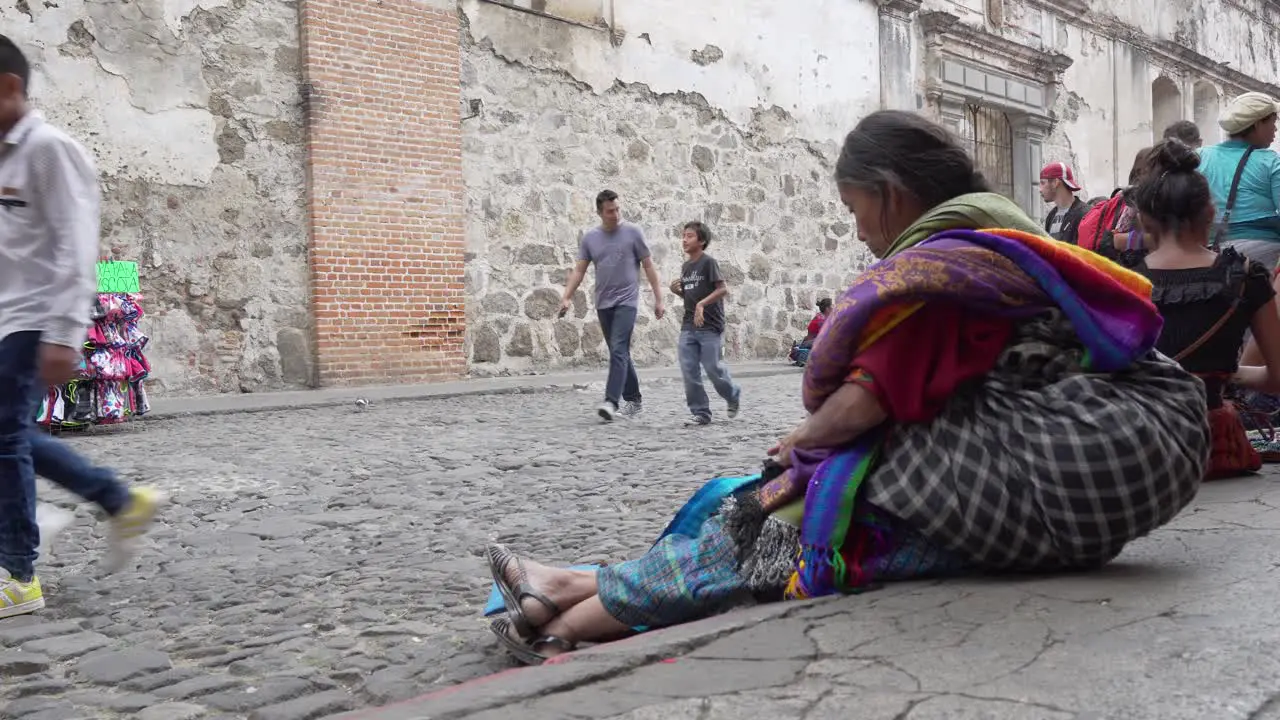 An elderly Maya woman passes time on the street in Antigua Guatemala