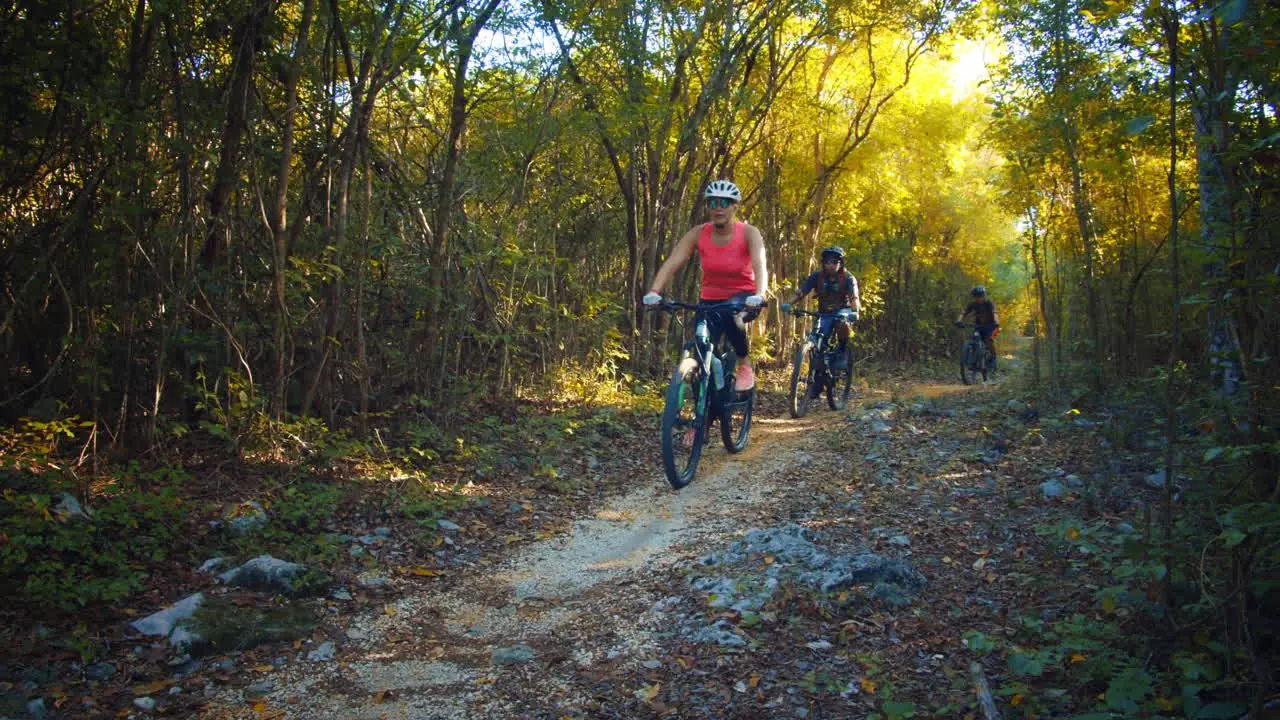 Slow Motion Mountain Bikers Cycling across the Forest Trail