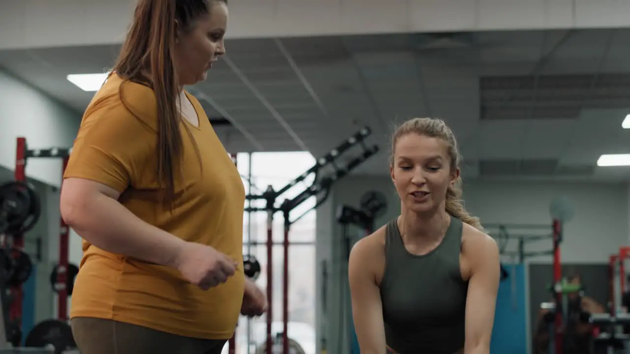 Caucasian female trainer showing how to make a exercises with rope at the gym 