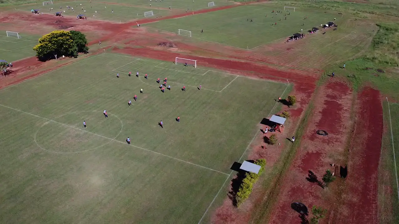 Drone orbit around active energenic football match referee waves flag and ends play