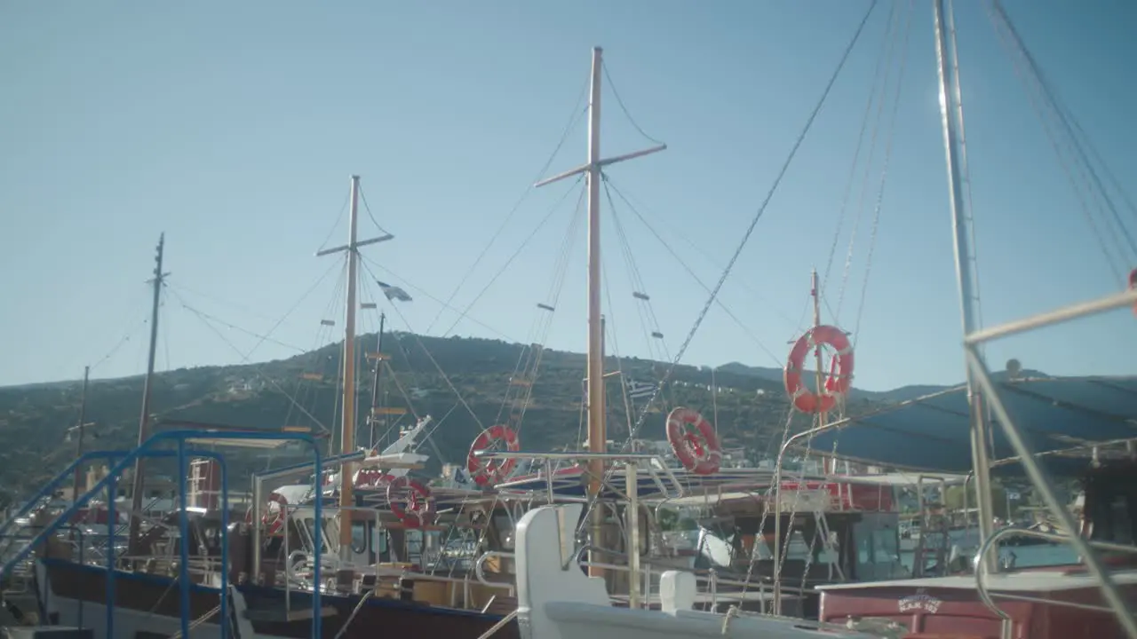 Wide shot of boat masts with flags flapping in the wind in harbour