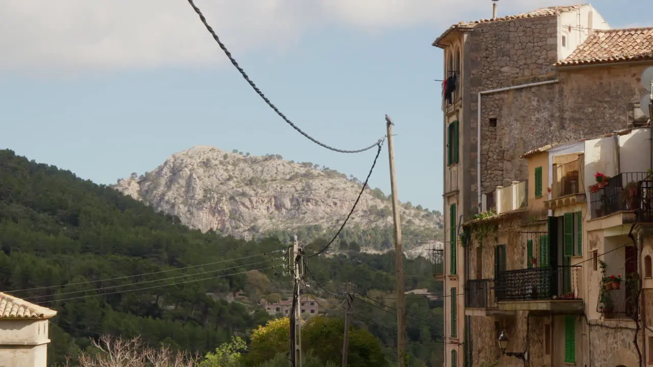 A captivating view of Valldemossa Mallorca Spain with mountains in the background and old houses lining the side