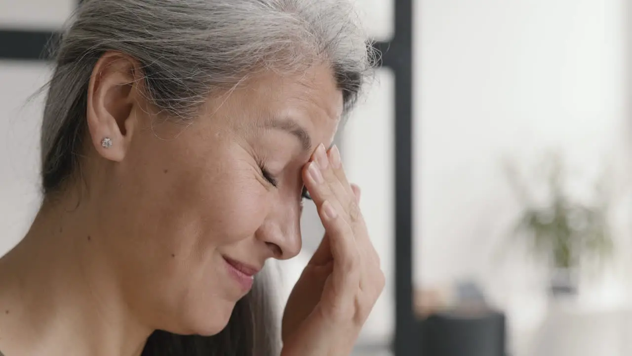 Close Up Of A Middle Aged Woman With A Migraine Holding The Bridge Of Her Nose