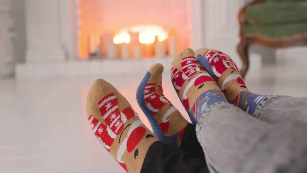 Paar Füße In Kuscheligen Weihnachtssocken Am Kamin 1