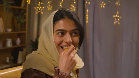 Muslim Family Sitting Around Table At Home Eating Meal To Celebrate Eid 3