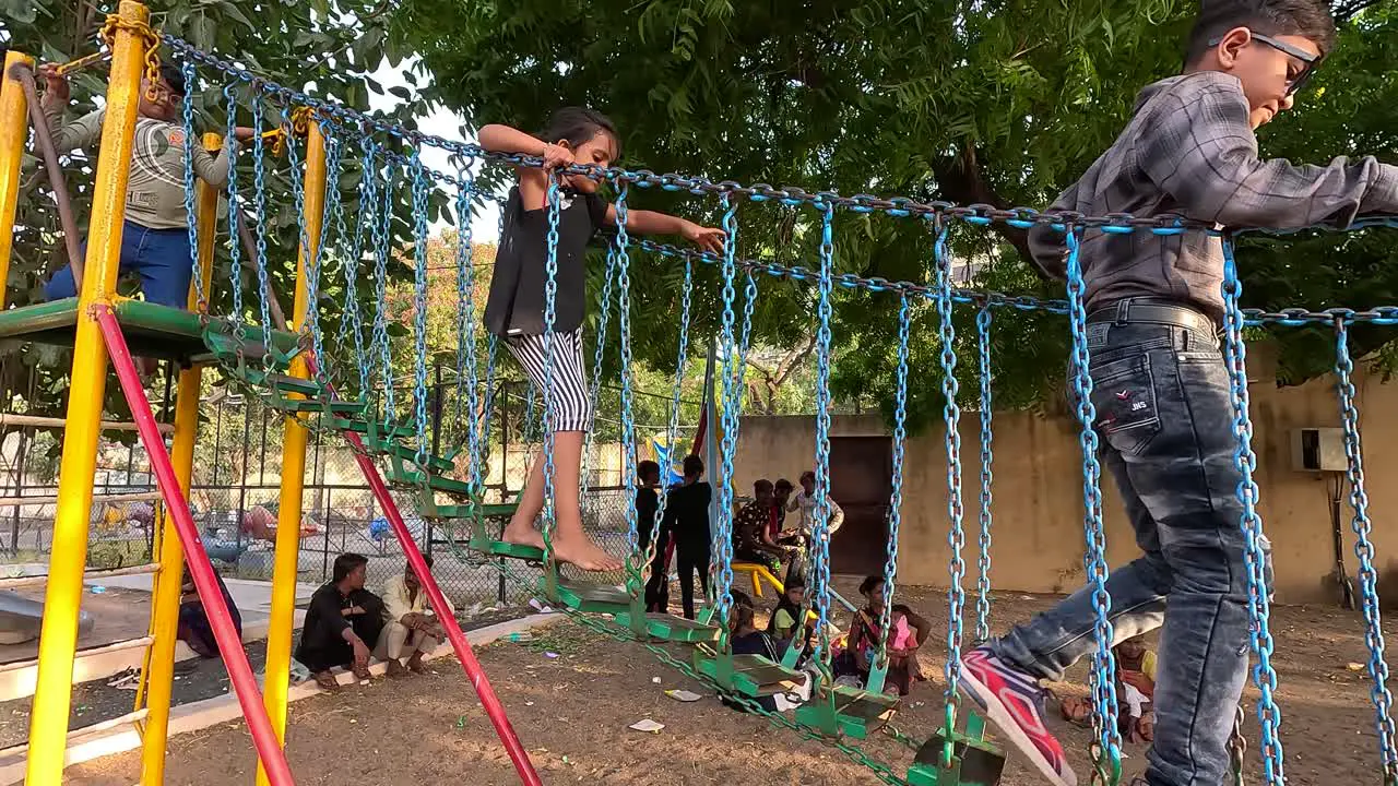 Little children are enjoying walking on the swing bridge during the holiday