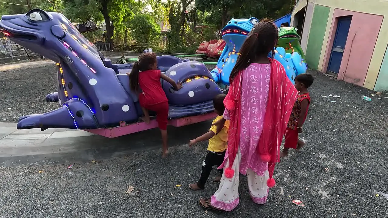 Little kids are sitting on the frog ride and enjoying their vacation