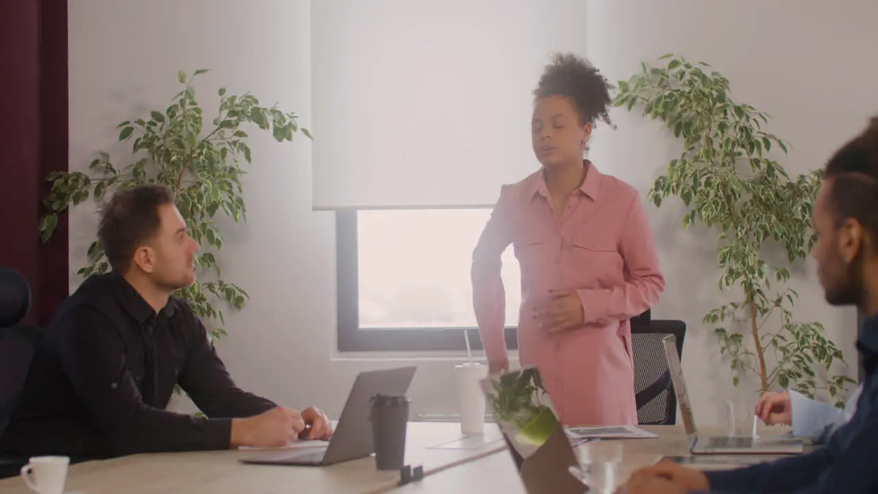 Mujer Embarazada Está Explicando Un Proyecto Frente A Sus Compañeros De Trabajo