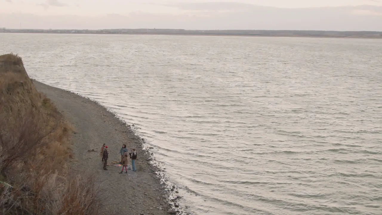 Vista De Drones De Un Grupo De Amigos Adolescentes Alrededor De La Hoguera Mientras Beben Té Y Comen Salchichas En La Orilla Del Mar