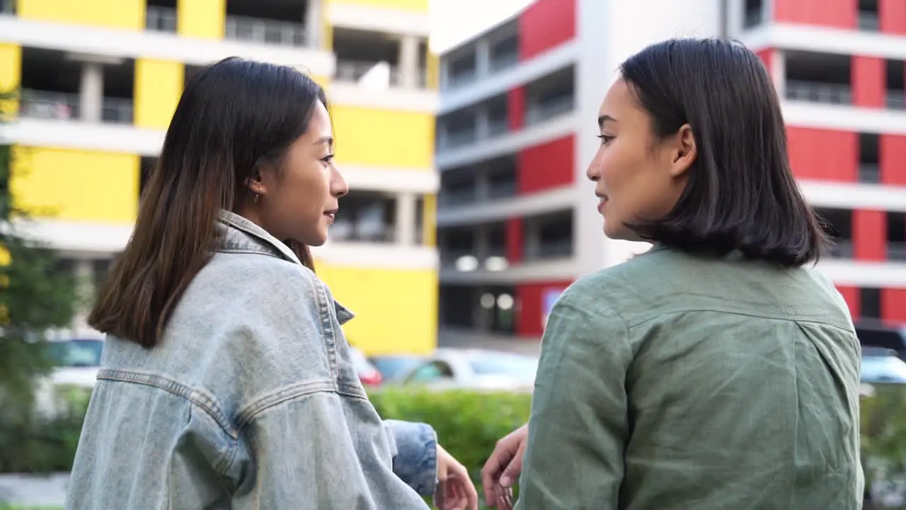 Vista Trasera De Dos Chicas Japonesas Muy Jóvenes Sentadas Y Hablando Juntas Al Aire Libre