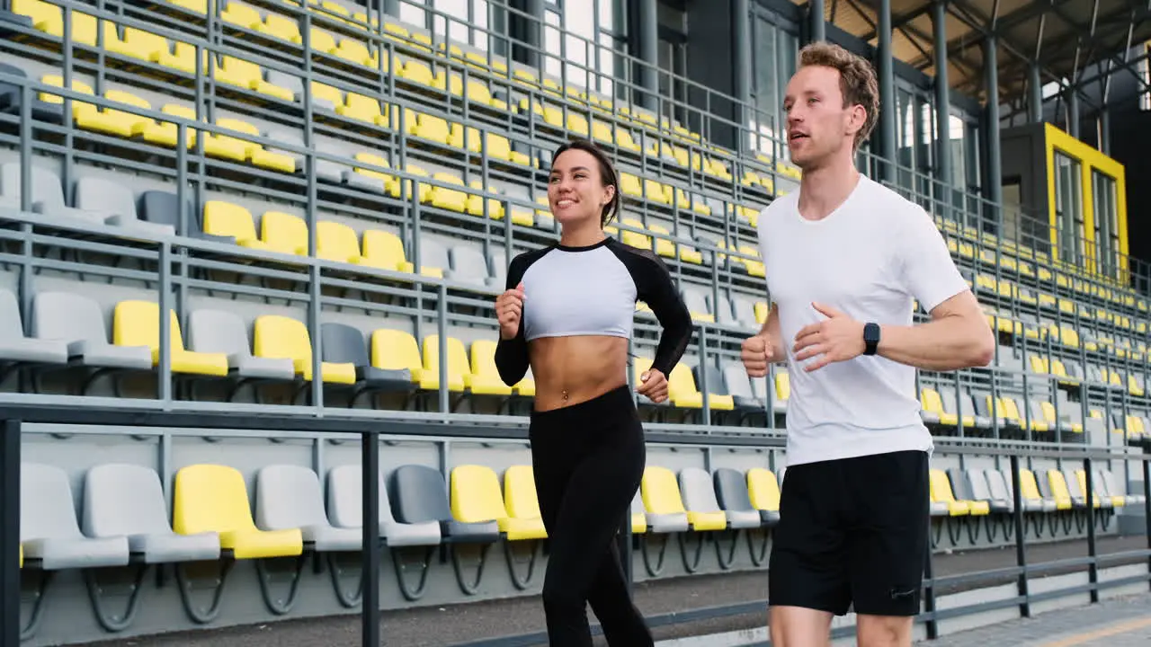 Feliz Pareja Deportiva Hablando Y Corriendo Juntos En El Estadio 1