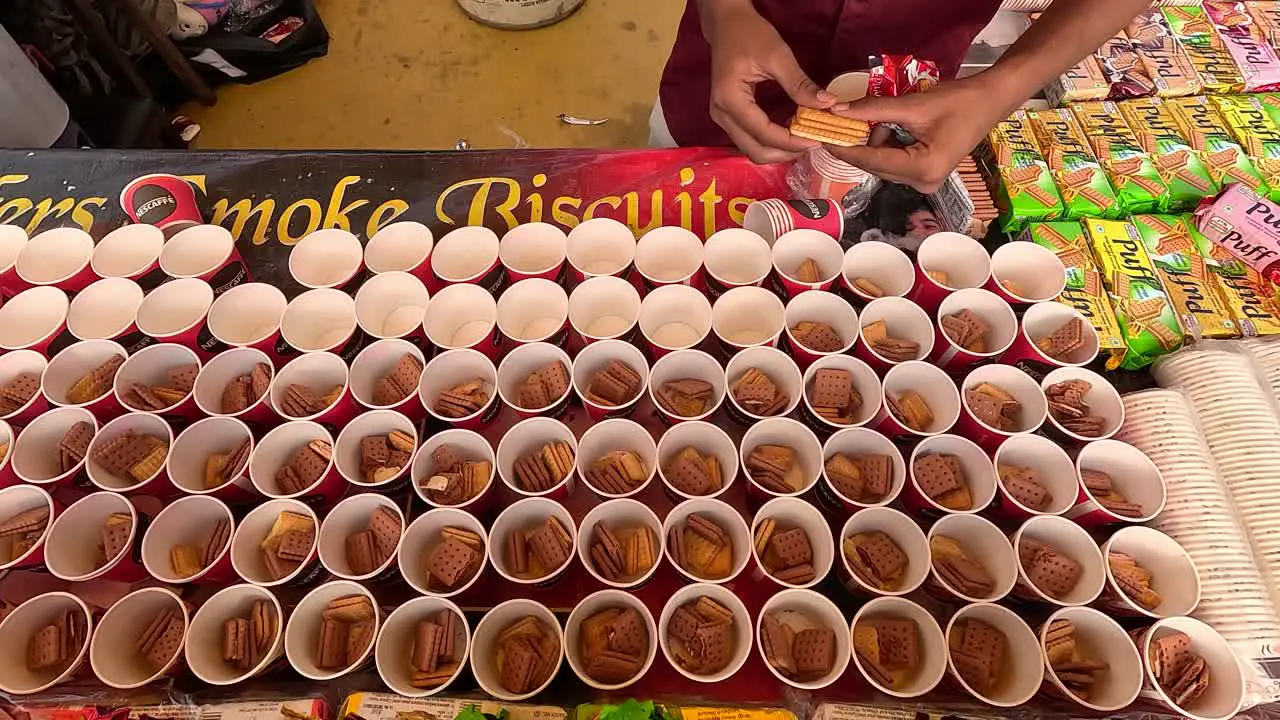 Ness Cafe Smoke Biscuits the shopkeeper is pouring biscuits into all the cups at his stall