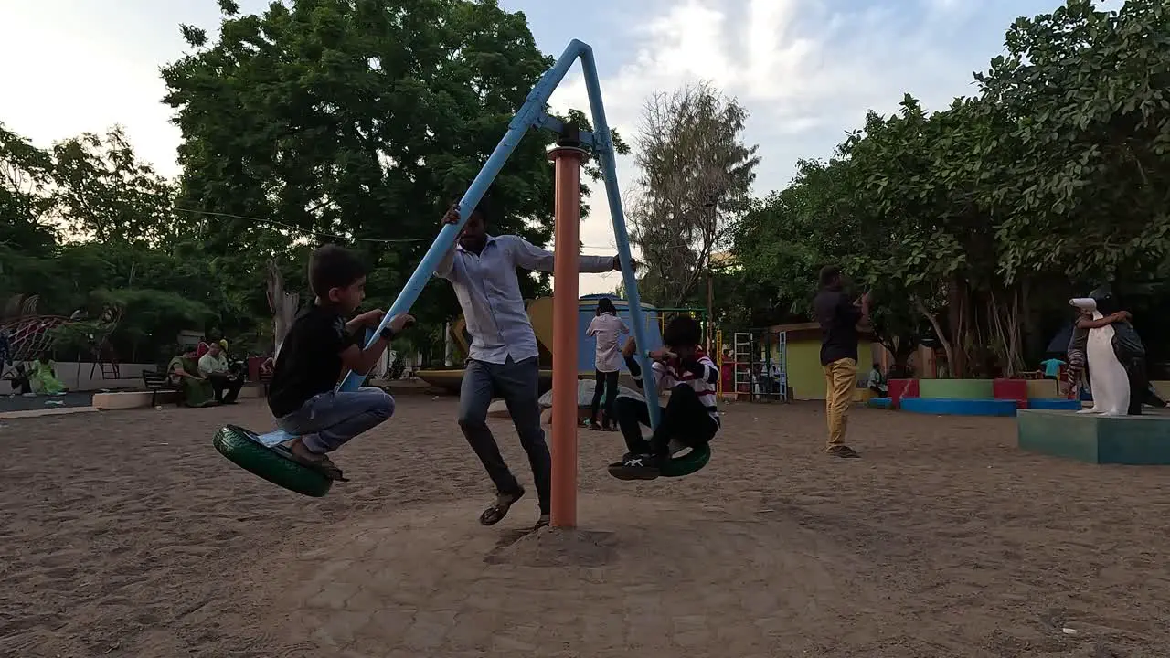 A father is taking his two children on a ride at an amusement park