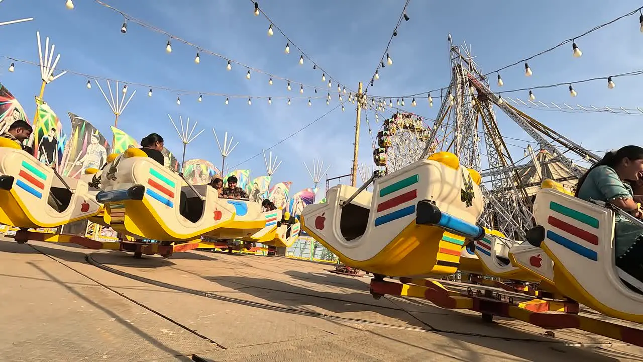 Wide Soot daytime amusement park breaking dance ride scene with couples enjoying themselves