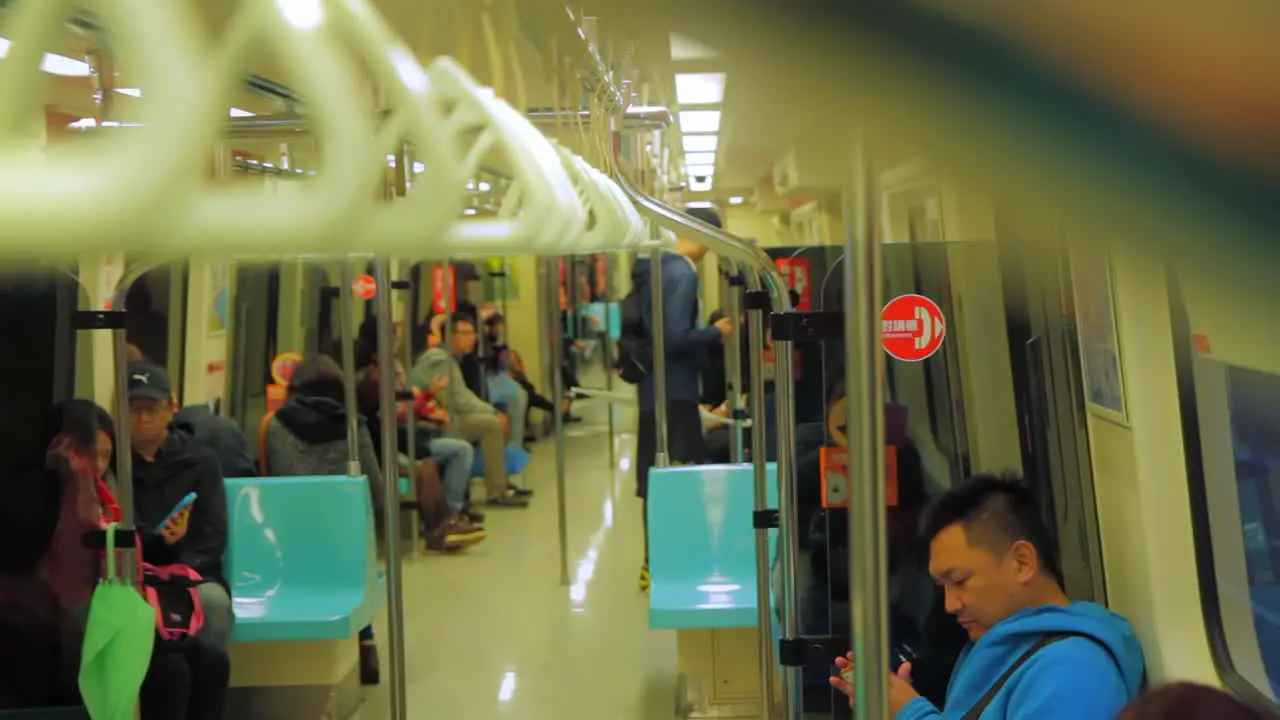 Interior of Taipei metro at night with Asian persons getting seated