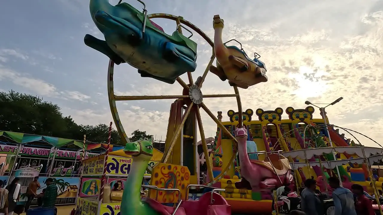 Sunset time scene colorful rounding animal ride in amusement park with little kids having fun