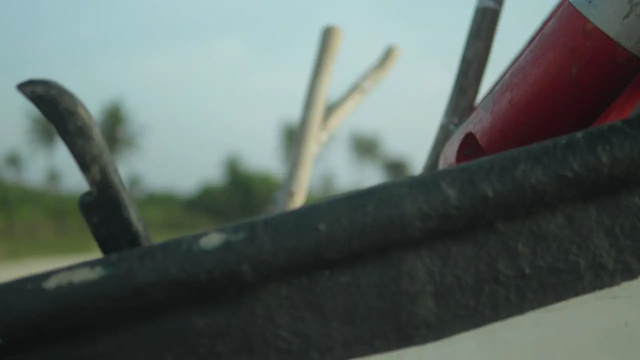 Close-up of a stranded boat with blurry greenery and beach in the background