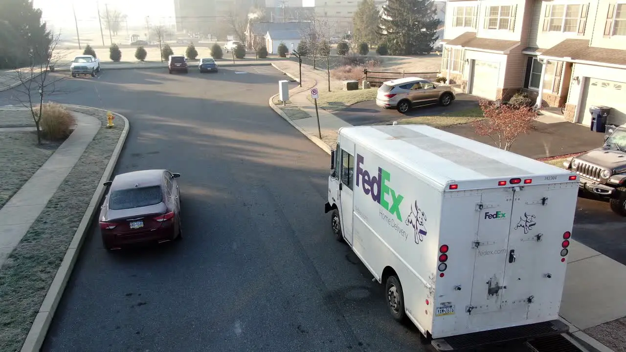 Door to door parcel delivery FedEx Ground van in street of residential area express delivery service