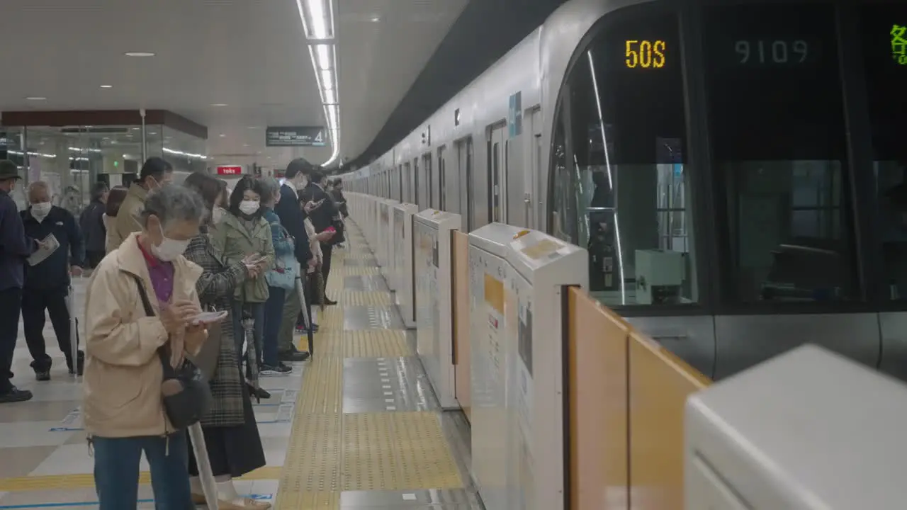 JR Train Approaching Station With People Wearing Face Masks Standing And Waiting On Platform Coronavirus Pandemic Outbreak In Tokyo Japan