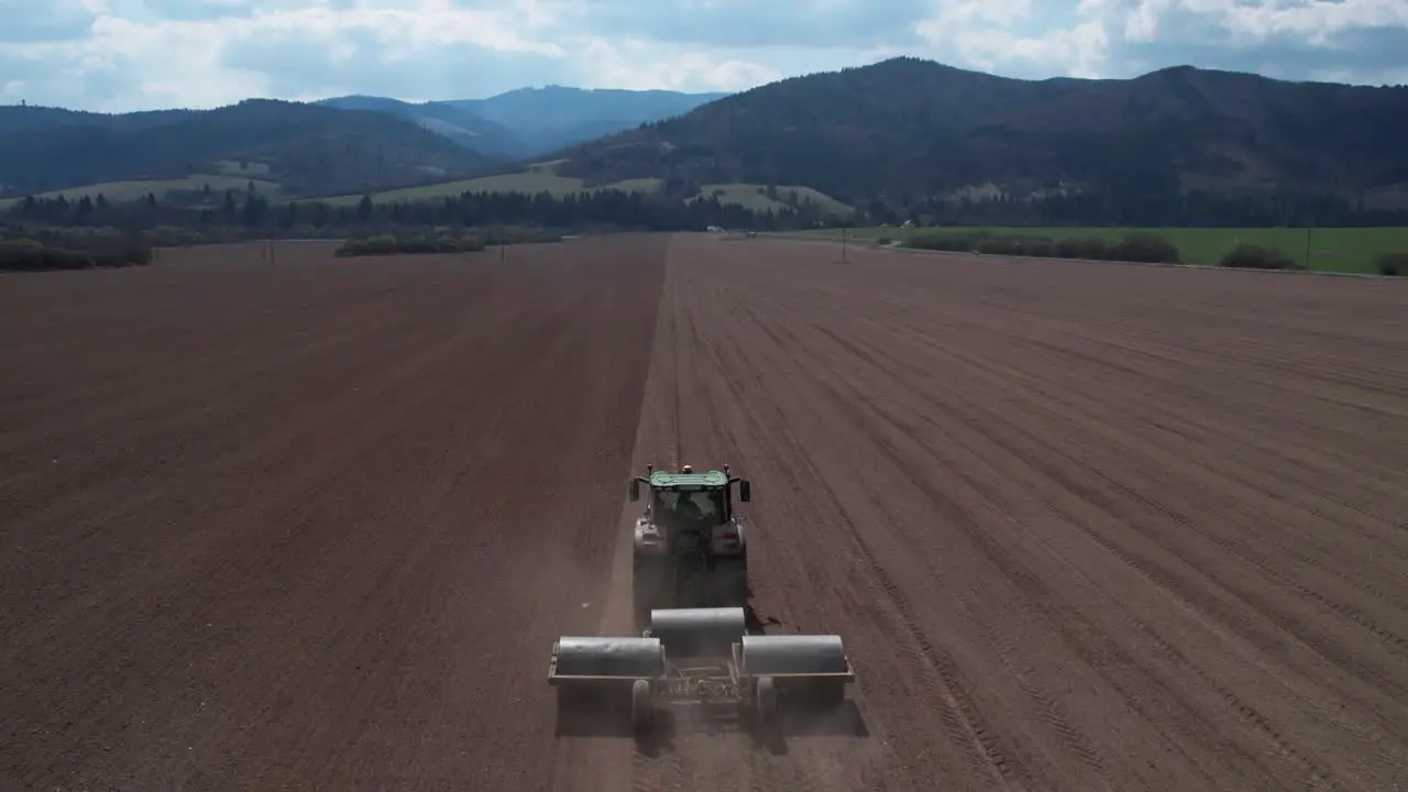 Food Industry Concept Aerial View of Tractor Preparing Farming Land For Another Seeding Season